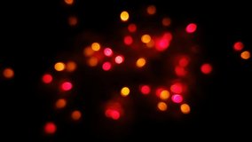 Beautiful blur bokeh background. Hand Arranging decoration shiny colorful glowing small bubbles light bulbs on blurry black night. Abstract Christmas and new year festive holiday eve party 4k video.