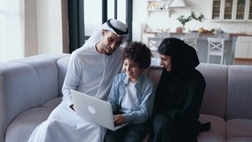 Cinematic footage of an arabian family spending time together at home. Lifestyle concept about people wearing emirates traditional clothes