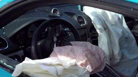 Broken sports car interior, with fired airbags