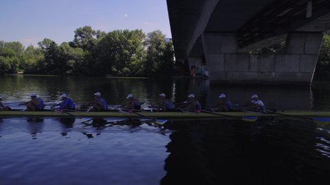 Rowing team summer training. 8 athletes rowers in a boat in the river Dnipro. City area in Kiev, Ukraine