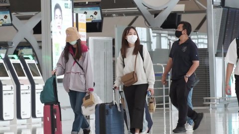 Bangkok, Thailand Circa 2021 
in the Airport, slow motion People walking through the Departure Hall of Airport of thailand, face mask. Safe travel tourism, Virus outbreak Coronavirus COVID-19