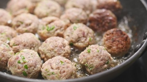 Cooking delicious small meatballs in frying pan.
