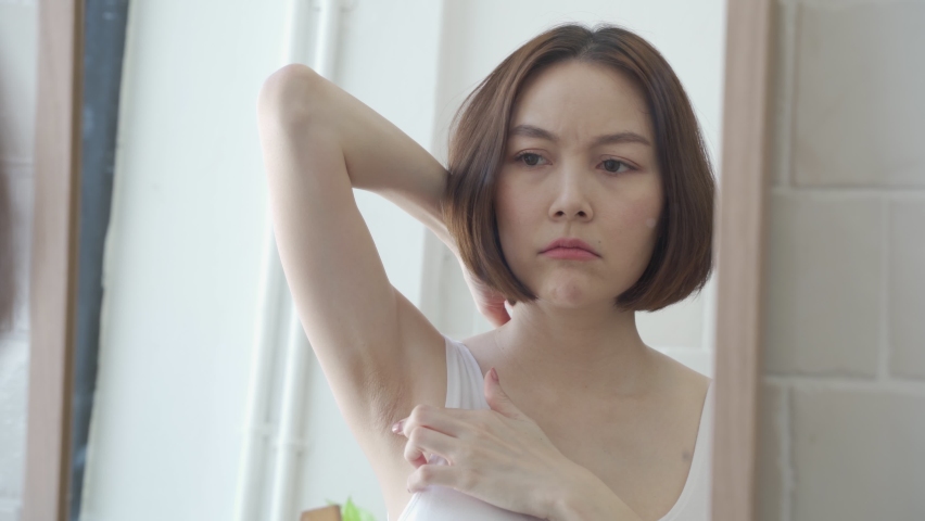 reflection mirror Asian female worry about black armpit with hair growing in bathroom at home. dark underarms concept. short hair woman looking mirror concern worried and Lack of confidence. problem. Royalty-Free Stock Footage #1073270567