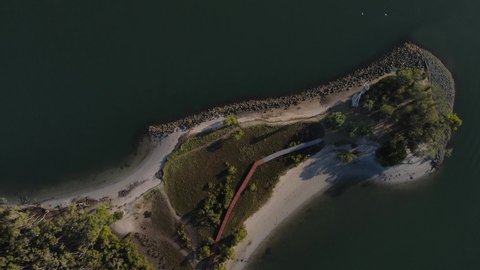 Fasting drone video looking down on a secret timber boardwalk winding through a coastal conservation wetland