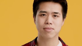 Cheerful Chinese Young Man Gesturing OK Sign Articulating Okay Smiling To Camera Posing Over Yellow Background. Portrait Of Asian Millennial Guy Showing Ok Symbol In Studio