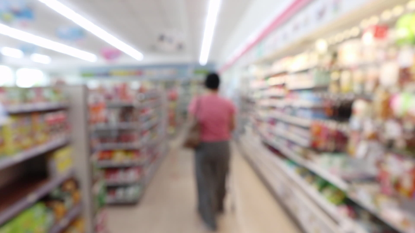 Customer shopping in supermarket convenience store  aisle interior shelves blur background Royalty-Free Stock Footage #1073301338