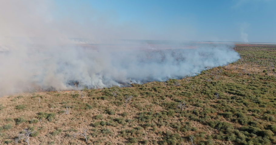 Climate emergency.Climate change. Global warming. Epic spectacular aerial panning view of smoke billowing from a grass fire caused by drought and climate change