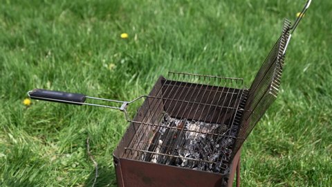 Brazier in nature at summer day. Charcoals in brazier for grilling food. Cooking barbeque on brazier. Prepare grilling charcoal heat for roasting meat. Concept of picnic with barbecue.