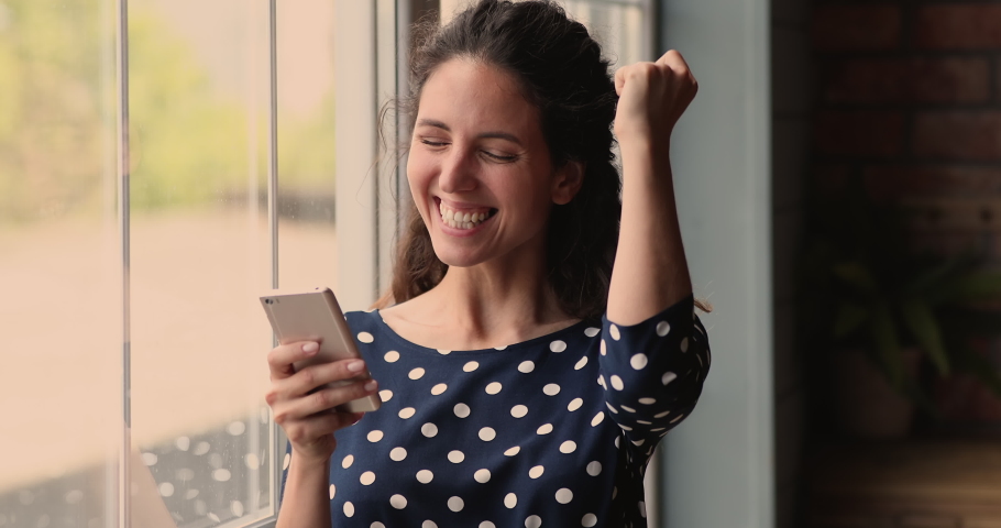 Head shot pretty millennial hispanic woman looking at cellphone screen, reading message with unbelievable good news, celebrating online lottery gambling giveaway win, getting secret sale notification. | Shutterstock HD Video #1073311679