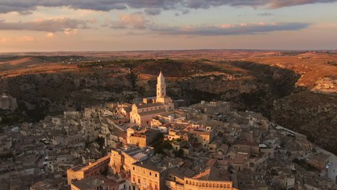 sassi di matera historic town aerial view,drone flying forward over old city center at dusk sunset