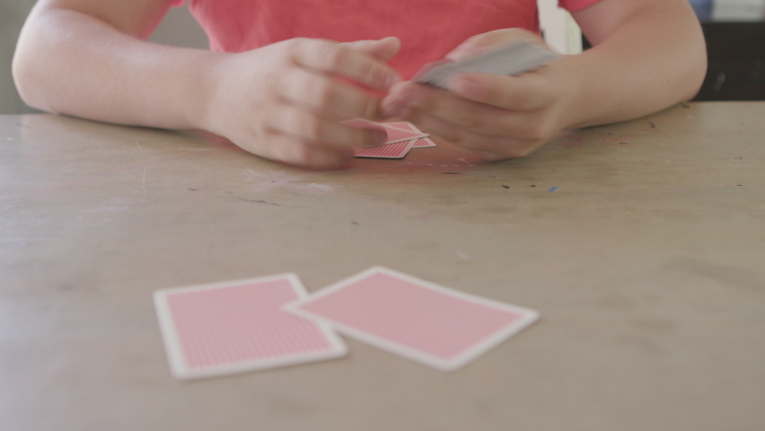 Teen boy playing cards deals cards to camera POV Royalty-Free Stock Footage #1073336951