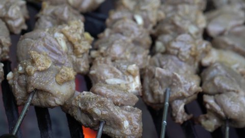 Extreme closeup sliding to the right of lamb skewers shish kabob on a hot grill.