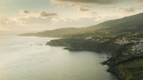 Sao Miguel island, Azores, Portugal. Drone footage over the volcanic island. Beautiful coast with a settlement by the Atlantic Ocean. High quality 4k footage