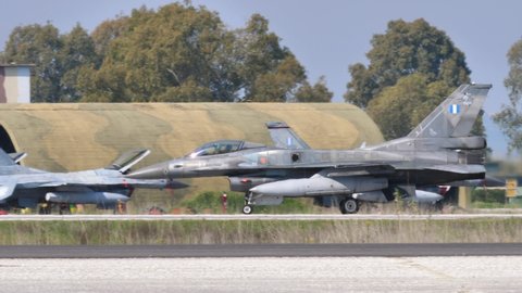 Andravida Greece APRIL, 03, 2019 Profile of a NATO grey combat jet plane taxiing with external fuel tanks also conformal. Lockheed Martin F-16 C Fighting Falcon or Viper of Hellenic Air Force