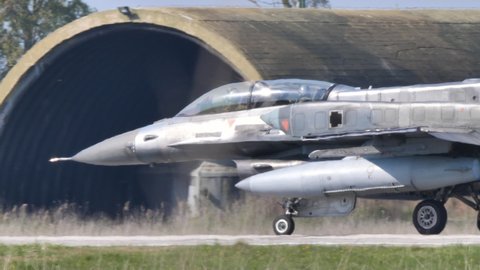 Andravida air Base Greece APRIL, 03, 2019 Two seats NATO grey military fighter jet for pilots training taxies on air base runway. Lockheed Martin F-16 Fighting Falcon or Viper of Hellenic Air Force