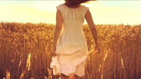 Beauty girl running on yellow wheat field over sunset sky. Freedom concept. Happy woman outdoors. Harvest. Wheat field in sunset. Slow motion 240 fps. Slowmo. 1080p full HD video footage