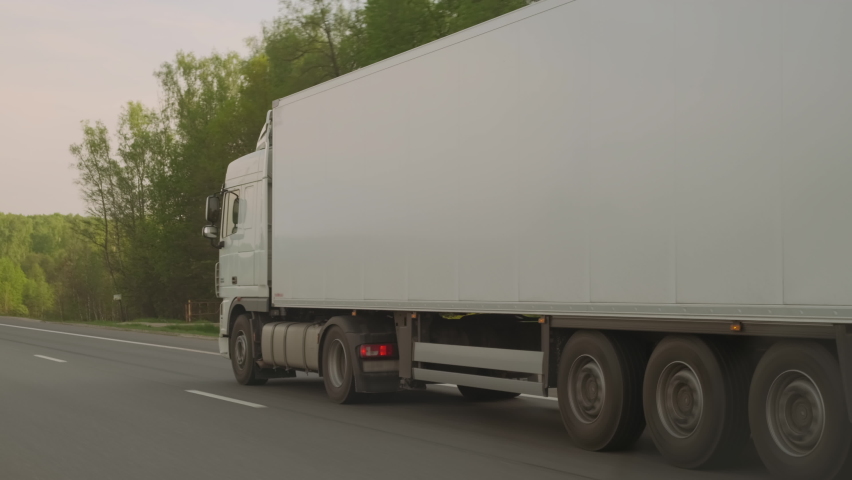 White truck with cargo trailer driving on highway carrying goods, insured trucking. Free place on semitrailer for copy space. | Shutterstock HD Video #1073348087