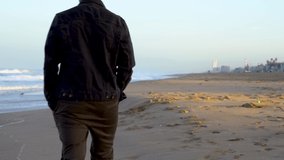 4k video. A young man walks on the beach in Los Angeles in the early morning