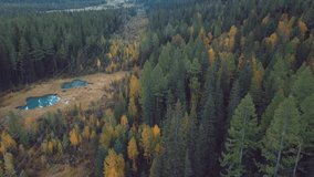4K Aerial Footage Video of the Autumn Forest and Geyser Lake with Clear Blue Water near the village of Aktash in the Altai Mountains, Russia