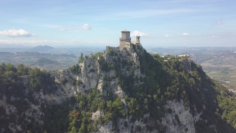 drone flying panoramic right and up around the san marino towers at the top of the mountain  in Italy