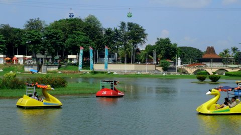 Jakarta, indonesia - May 30, 2021 : People on vacation riding water duck recreation vehicles on the  lake in Taman Mini Indonesia Indah (TMII park) , East Jakarta .