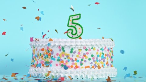 Birthday Cake With Burning Colorful Candle with Number 5 on Pastel Background. Falling confetti.