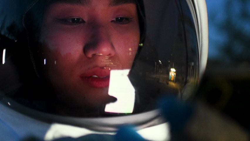 Close-up of Asian astronaut looking at digital device