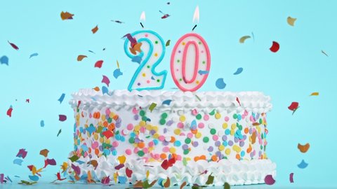 Birthday Cake With Burning Colorful Candles with Number 20 on Pastel Background. Falling confetti.