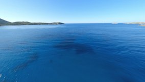 View from above, stunning aerial video shoot by an FPV drone flying at high speed over a turquoise water. Mediterranean sea, Costa Smeralda, Sardinia, Italy.
