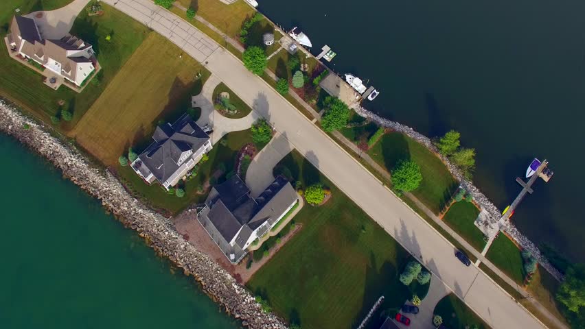 Aerial View of Scenic Waterfront Peninsula with Houses, Boats, Docks.

