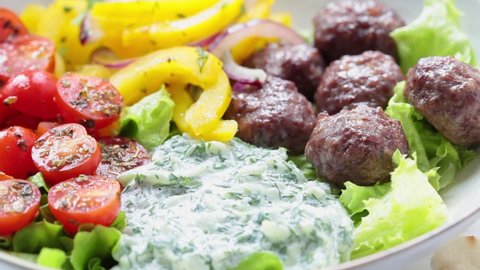 Greek food concept. Meatballs, tzatziki sauce, tomato and cucumber salad.