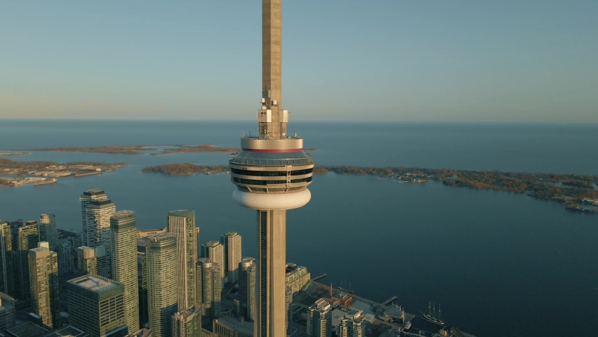 Toronto, Ontario  Canada - March 21, 2021: Aerial view around the CN Tower during golden hour with Toronto skyline and Lake Ontario in the background, Ontario, Canada