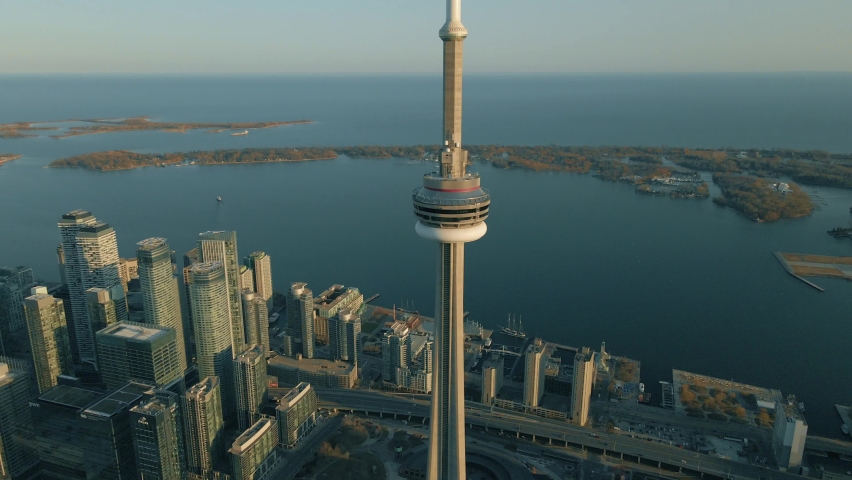 Toronto, Ontario  Canada - March 21, 2021: Aerial view around the CN Tower during golden hour with Toronto skyline and Lake Ontario in the background, Ontario, Canada