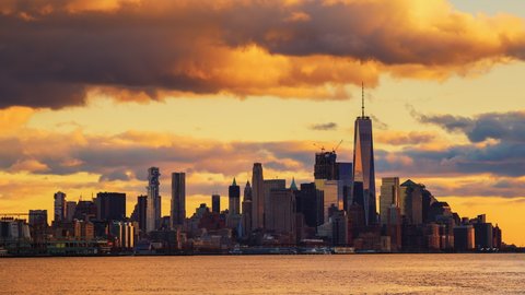 New York City sunset to dusk timelapse of dramatic sunset clouds moving fast over Lower Manhattan Financial District building and Hudson river. New York City at sunset. Long term timelapse. 스톡 비디오