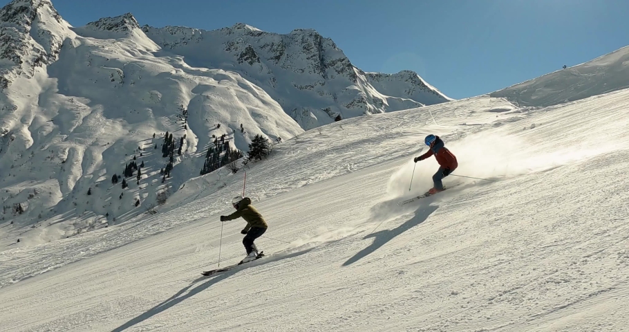 Ski show of two young male skier in beautiful mountain landscape with high speed. Cold winter day high up in the mountains in a ski resort. Rhytmic ski show with great panorama 4k follow camera. | Shutterstock HD Video #1073388188
