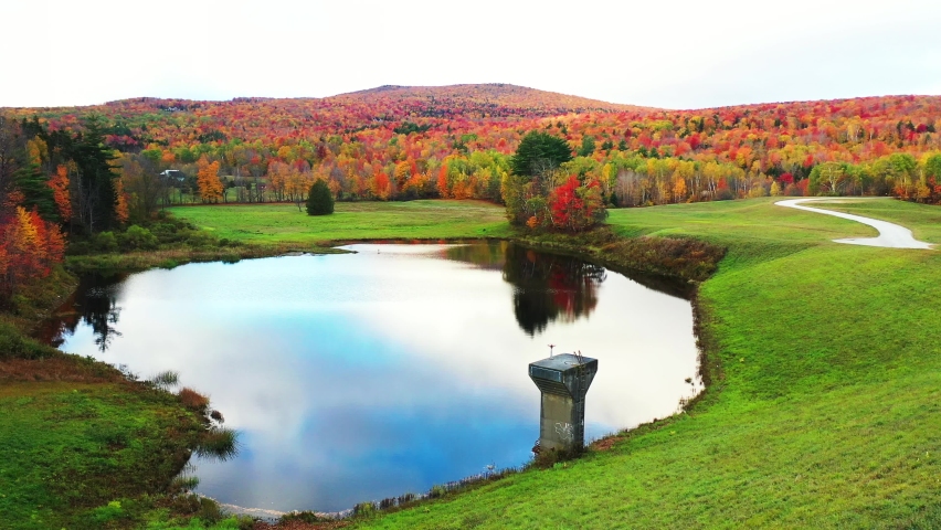 Vivid Autumn Landscape, Blue Pond Water With Sky Mirror Reflection and Colorful Forest Foliage, Drone Aerial View