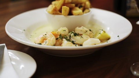 Dolly forward of Shrimp in cream sauce and French fries dish. Restaurant concept
