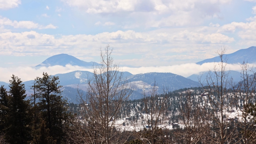 Low clouds building during a timelapse during the spring with snow on the ground, viewing the Lost Creek Wilderness and Green Mountain in the Pike National Forest in the Rock Mountains, Colorado, USA.