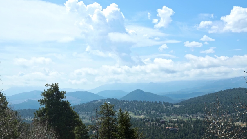 Partly cloudy during a timelapse during the spring with green grass, viewing the Lost Creek Wilderness and Pike National Forest in the Rock Mountains, Colorado, USA.