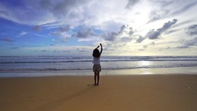 Silhouette Asian teen girl 6 years old standing on beach at sunset raising arms on beach enjoying Amazing sunset or sunrise on summer travel vacation holiday Happiness travel and bliss concept video