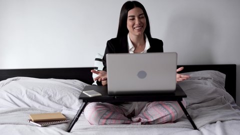 Young latin woman working form home with laptop computer while talking on a video call