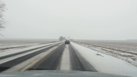 Winter driving on snowy road surface following another car