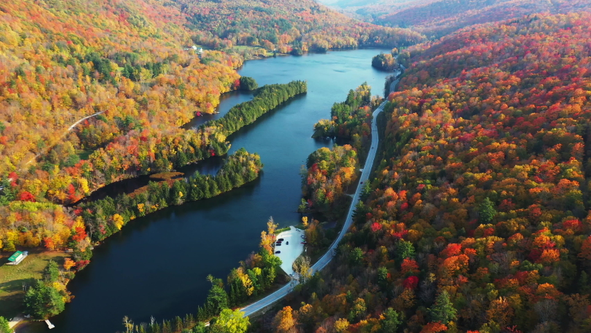 Breathtaking Autumn Landscape, Colorful Forest Foliage and Blue Lake Under Sun. Aerial View of Vermont USA Countryside on Fall Day, Drone Shot