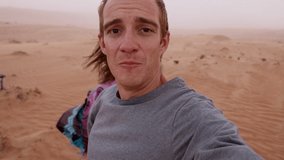 Video blogger talking to camera during desert sandstorm. 