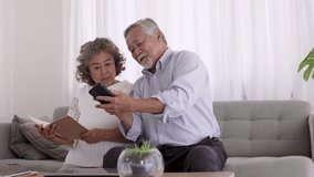 Couple Asian elderly video conferent online with smart phone  in living room.