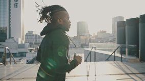 Sport and modern technologies. Active african american guy jogging in urban area, turning on activity tracker on smartwatch and start running, tracking shot - Powered by Shutterstock - Get 15% off with code: PIKWIZARD15