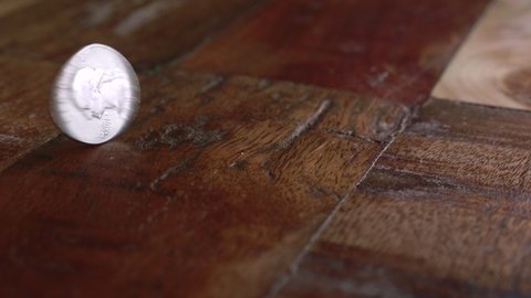 Coin Spinning On Wooden Floor - Copper-nickel Clad Copper Washington Quarter. - close up