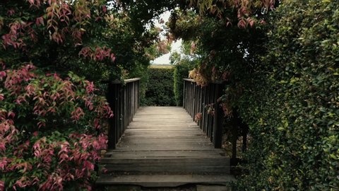 Wooden Bridge Towards Labyrinth, Hedge Maze In Wauchope, NSW, Australia - Bago Maze and Winery. - handheld shot