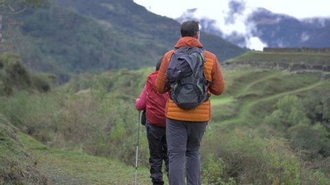 Couple walking to Archaeological inca ruins, in middle of the mountains, vitcos, road to vilcabamba, machu picc
