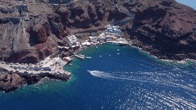 Aerial drone video of beautiful bay of Ammoudi below picturesque village of Oia, Cyclades, Greece